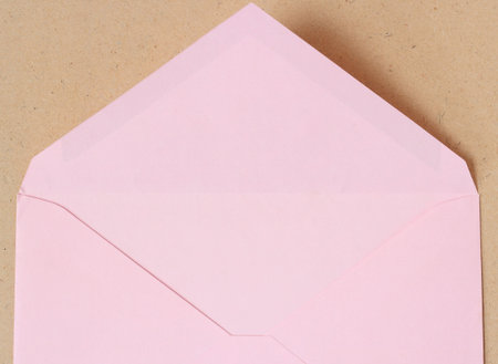 pink open envelope on wood background