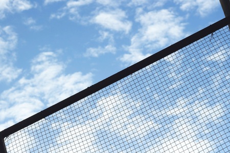 Silhouette of Structure mesh metal fence on sky backgroundの写真素材