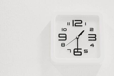 soft white clock on white wall backgroundの写真素材