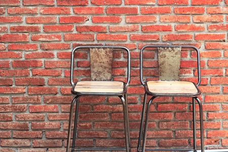 Outdoor steel chair on red brick wallの写真素材