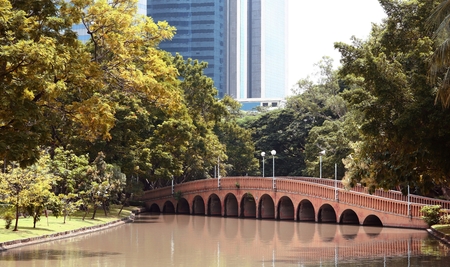 Arch brick bridge over the lake at Jatujak(Chatuchak) public city park in Bangkok,Thailandの写真素材