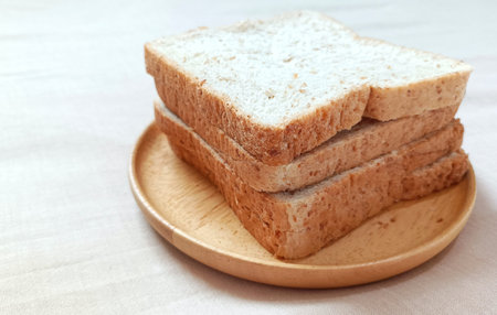 Whole wheat bread sliced â€‹â€‹on wooden plate