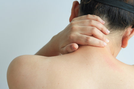 Female hand massaging the back of the neck or office syndrome, health conceptの写真素材