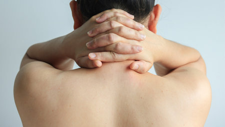 Female hand massaging the back of the neck or office syndrome, health conceptの写真素材