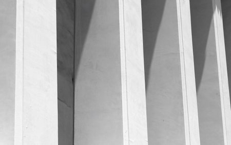 Concrete pillars under a construction building with evening light and shadowsの写真素材