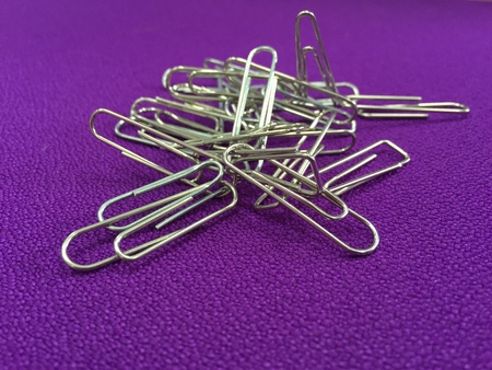 Image of silver paper clip isolated on purple backgroundの写真素材