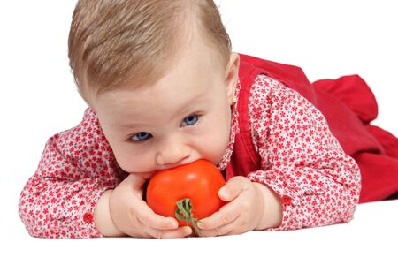 Portrait of a girl with red dress and  a tomato in the handsの写真素材