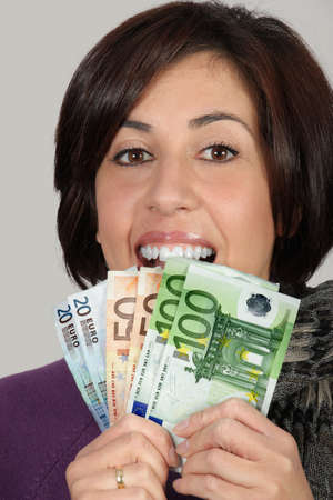 Woman with purple jacket and gray scarf with with euro billsの写真素材