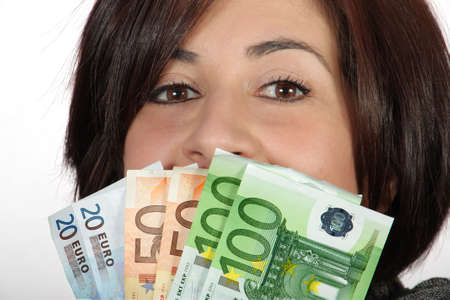 Woman with purple jacket and gray scarf with with euro billsの写真素材