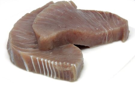 Two fillets of raw tuna steak on a white plateの写真素材