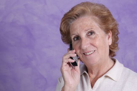 Portrait of a elderly woman with serene look on a purple backgroundの写真素材
