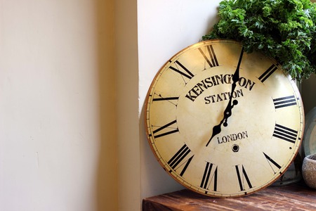 white wooden wall decorated with clocks and glass bottlesの写真素材