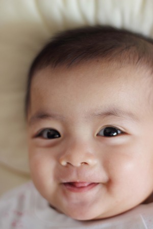 Beautiful baby smiling looking at cameraの写真素材