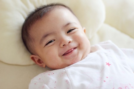 Beautiful baby smiling looking at cameraの写真素材