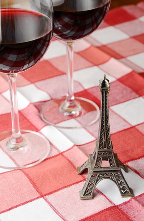 Souvenir Eiffel towe and a pair of wineglasses on the tableの写真素材