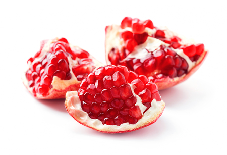 piece of red ripe pomegranate with lot of seeds isolated on white backgroundの写真素材