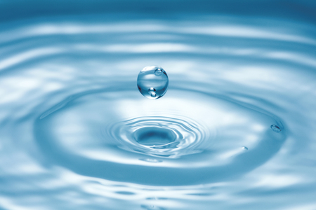 close-up view of droplet splash on blue water surfaceの写真素材