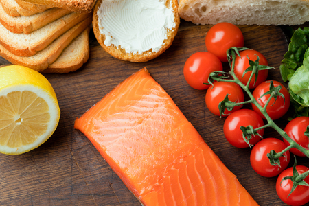 Smoked salmon fillet with vegetables on wooden backgroundの写真素材