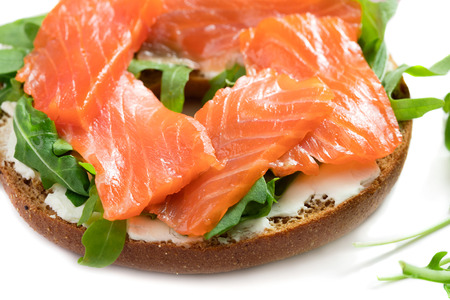 single fresh bagel sandwich with salmon, arugula and cream cheese isolated on white backgroundの写真素材