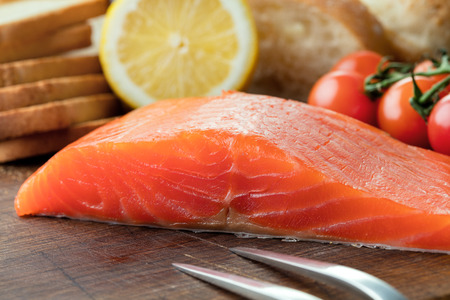 smoked salmon fillet with vegetables on wooden backgroundの写真素材