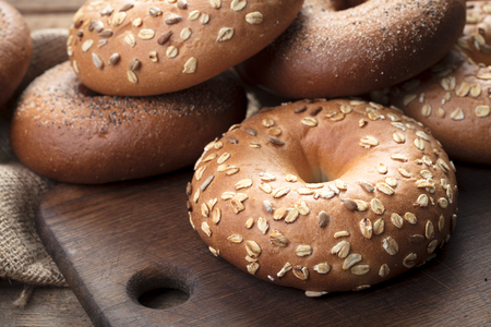 heap of fresh baked bagels on wooden backgroundの写真素材