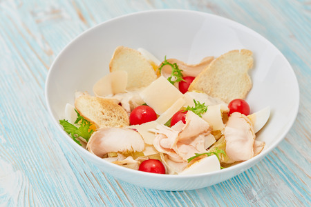 bowl of fresh salad on blue wooden tableの写真素材