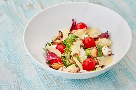 bowl of fresh salad on blue wooden tableの写真素材