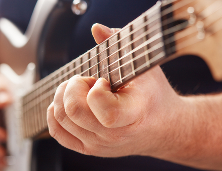 close-up of male hands playing electric guitarの写真素材