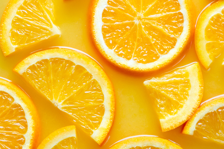 top view of orange slices in juice as texured backgroundの写真素材