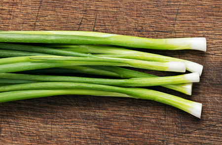 heap of green onion on wooden backgroundの写真素材