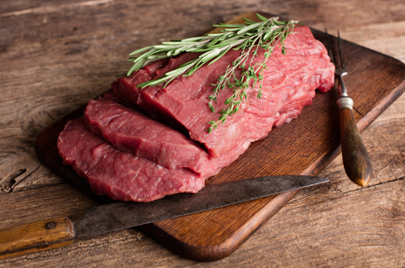 big piece of raw beef meat on wooden tableの写真素材