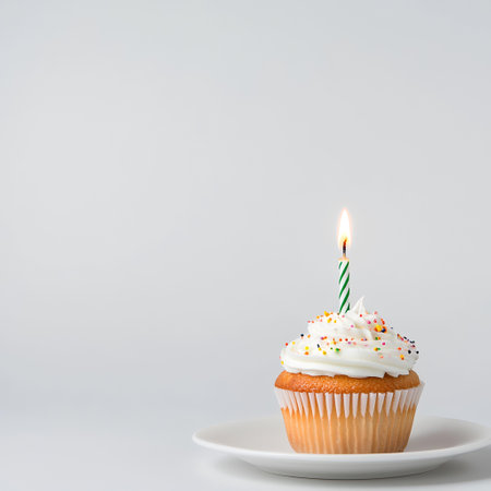 Single cupcake with candle, white background, celebration. AI Generatedの素材