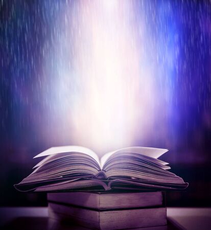Magic book, abstract blue light on a wooden backgroundの写真素材