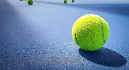 Close-up shots of tennis balls on a blue background fieldの写真素材