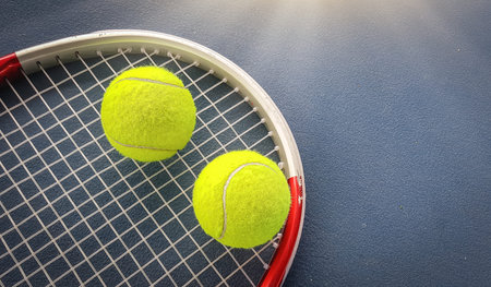 Close up view of tennis racket and balls on the tennis court