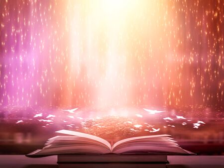 The blurred book that is bewitched with magic, the magic light in the dark, with the bright light shining down as the power to search for knowledge. For research and use as a blurred backgroundの写真素材