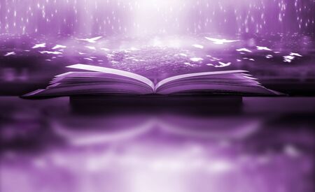The blurred book that is bewitched with magic, the magic light in the dark, with the bright light shining down as the power to search for knowledge. For research and use as a blurred backgroundの写真素材