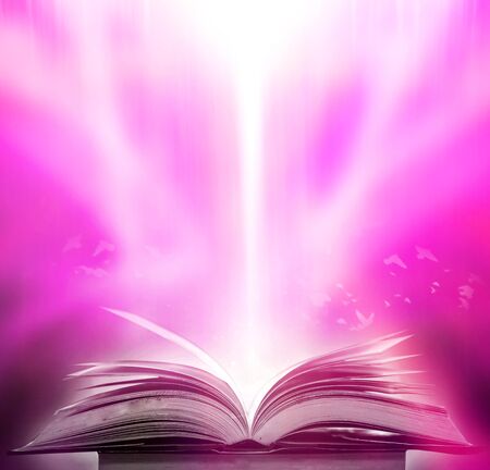 The blurred book that is bewitched with magic, the magic light in the dark, with the bright light shining down as the power to search for knowledge. For research and use as a blurred backgroundの写真素材