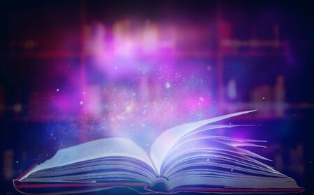 The blurred book that is bewitched with magic, the magic light in the dark, with the bright light shining down as the power to search for knowledge. For research and use as a blurred backgroundの写真素材