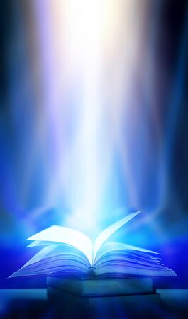 An ancient book that opens with magic, the magic light in the darkness on the wooden table, by the bright light shining down as the power to search for knowledge, religion and backgroundの写真素材