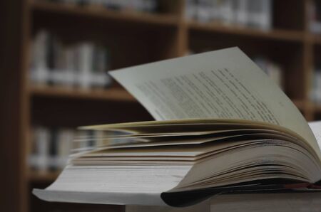 Stack of books in the library and blur bookshelf backgroundの写真素材