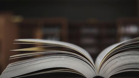 Stack of books in the library and blur bookshelf backgroundの写真素材