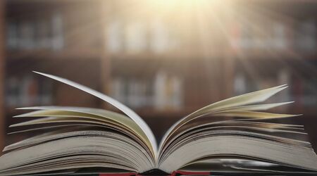 Stack of books in the library and blur bookshelf backgroundの写真素材