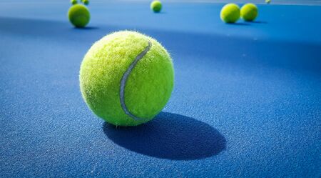 Close-up shots of tennis balls on a blue background fieldの写真素材
