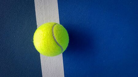 Close-up shots of tennis balls in tennis courts With a mesh as a blurred background And the light shining on the ground makes the image beautifulの写真素材