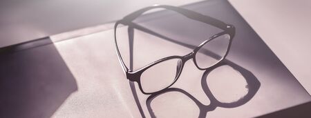 Glasses placed on the laptop in the library.の写真素材