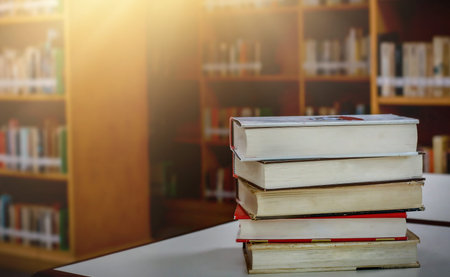Stack of books in the library and blur bookshelf background