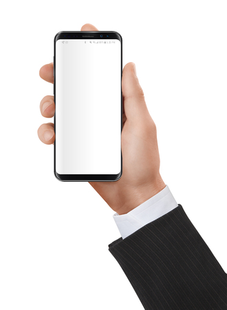 Elegant dressed man holding a smartphone in his hands with neutral white screen.の写真素材