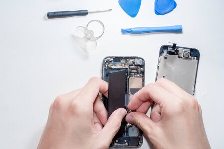 The smartphone was damages and need to repair  which tools smartphone that stand isolated on white background by hands of repairman.の写真素材