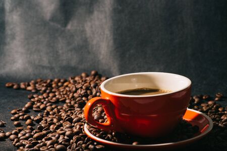 coffee in red cup and coffee beans are the background.の写真素材